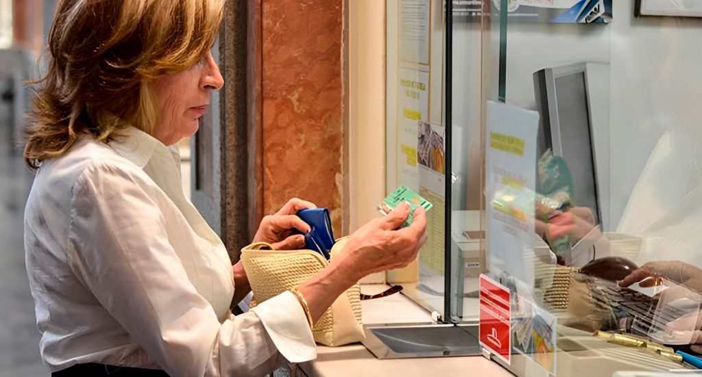 Señora mayor enseñando su carnet de pensionista al comprar su billete de transporte | Sevilla Senior